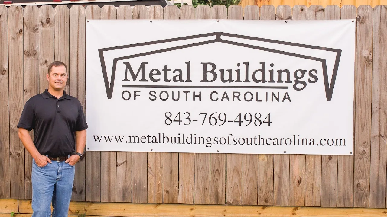 Patrick Schroder beside the company’s Metal Buildings of South Carolina sign