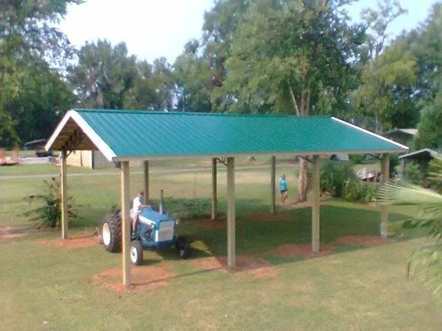 Open pole barn shelter with equipment underneath